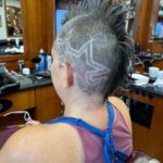 Thumbnail image of a barber using a straight razor for a precise cut