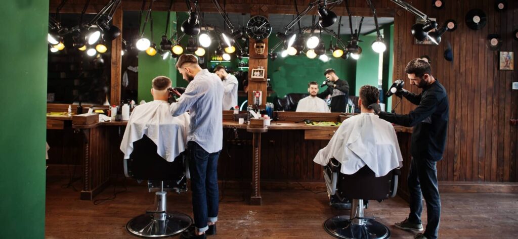 Close-up shot of a barber cutting hair with scissors and comb